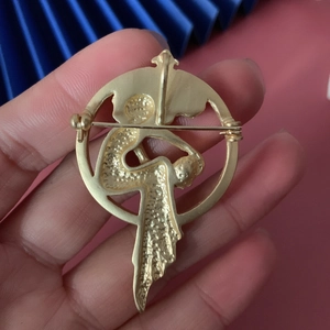 Vintage matte gold brooch featuring an elegant dancer silhouette in a round frame