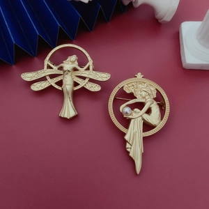 Detail of matte gold baroque angel brooch with delicate wings and a white pearl accent