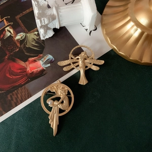 Detailed relief of vintage matte gold goddess brooch with elegant pearl embellishment