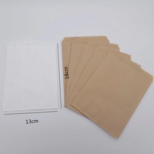 Detailed view of eco-friendly paper bags showing dimensions 13x18cm in white and brown
