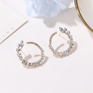 Detail of gold hoop earrings with marquise-cut zircons arranged in a leaf pattern