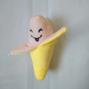 Close-up of humanized banana plush dog toy with cute embroidery on soft yellow fabric