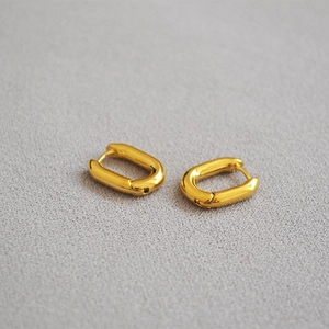 Détail de boucles d'oreilles créoles ovales en U en laiton plaqué or au design minimaliste