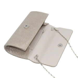 Detail of champagne glitter evening clutch featuring magnetic closure and gold chain strap