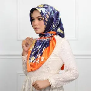 Detailed view of dark blue and orange satin square scarf with elegant floral patterns
