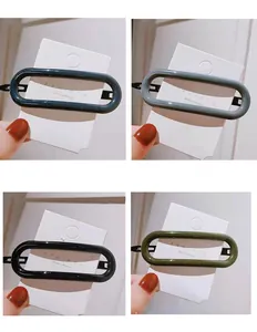 Acrylic oval hair clips in navy blue, grey, black, and olive green on display cards