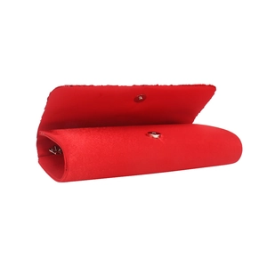 Détail d'une pochette en satin rouge montrant le fermoir magnétique et l'intérieur
