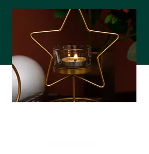 Detail eines goldfarbenen Metallkerzenhalters in Sternform mit Glas und Teelicht