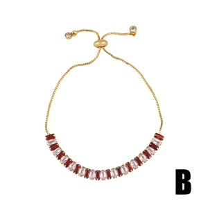 Detail of adjustable gold bracelet with red and white rectangular zircon gemstones