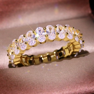 Luxurious gold eternity ring with oval-cut cubic zirconia stones on pink fabric