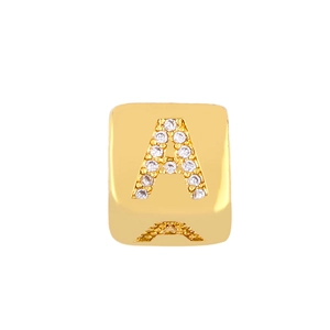 Detailed macro shot of a golden letter A cube pendant with sparkling zircon inlay