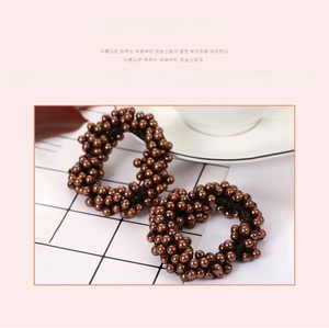 Détails de chouchous tressés marron café avec perles et cristaux élégants