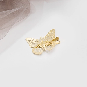 Détail macro d'une pince à cheveux papillon dorée avec artisanat en métal évidé élégant