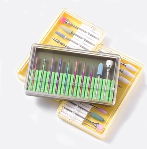Close-up of ceramic and alloy nail drill bits set with rainbow finish in storage cases
