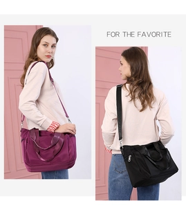 Detail of purple and black nylon tote bag featuring water-repellent fabric and thick handles