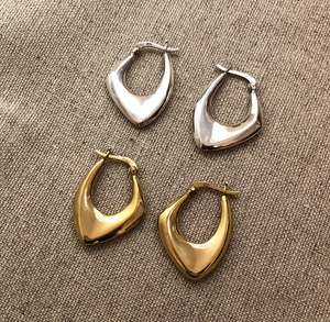 Close-up of gold and silver S925 sterling silver geometric earrings on burlap