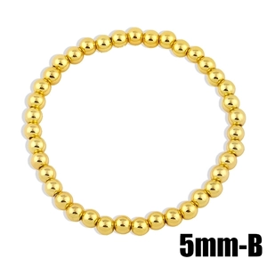Detalle de una pulsera elástica de cuentas doradas pulidas de 5 mm con brillo