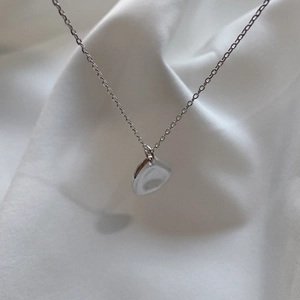 Minimalist 925 sterling silver geometric pendant necklace on white fabric background