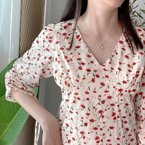 Detail view of V-neck floral summer dress with gathered sleeve accents and red patterns