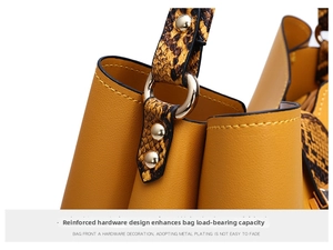 Detailed close-up of golden metal rings and snakeskin pattern handles on yellow handbag
