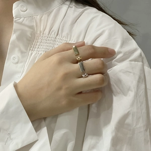 Minimalist D-shaped geometric 925 silver rings in gold and silver on a model's hand