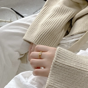 Detailed shot of gold twisted band ring with a rectangular clear zircon on a hand
