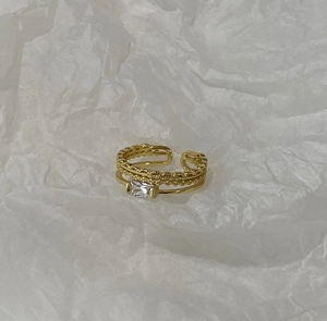 Detail of gold layered open ring with beaded texture and rectangular zircon stone