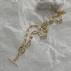 Detailed view of a gold chunky chain necklace featuring a stylish minimalist OT toggle clasp