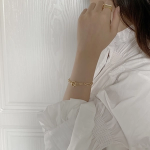 Detail of 925 sterling silver chain bracelet with gold OT buckle on model's wrist