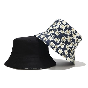 Reversible daisy floral and solid black bucket hat for sun protection and outdoor leisure