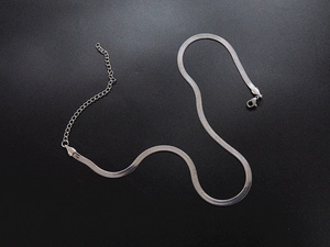 Macro view of silver snake chain necklace with lobster clasp and extension links