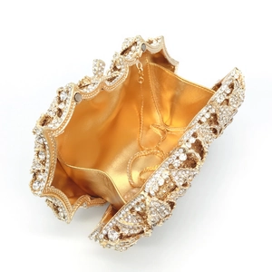 Detailed macro view of gold-tone hollow rose metal clutch with sparkling rhinestones
