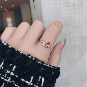 Close-up of elegant rose gold floral ring with colorful crystals worn on a female hand