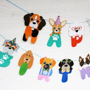 Close-up of cartoon dog birthday banner with HAPPY BIRTH lettering on white brick wall