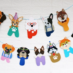 Close-up of paper banner with cartoon dog faces spelling HAPPY for pet birthday parties