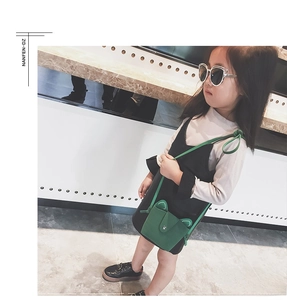 Green kids cat ear purse crossbody bag worn by child model in minimalist setting
