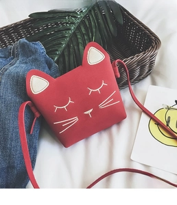 Detail of red cat-shaped shoulder bag for girls featuring cute embroidered kitten face