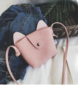 Detailed view of pink cat ear mini shoulder bag with magnetic snap and faux leather texture