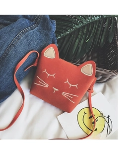 Detailed embroidery of a sleeping cat face on a rust-red suede kids crossbody bag