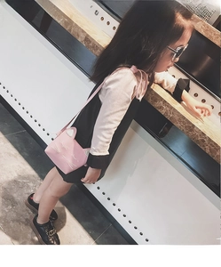 Pink PU leather cat-shaped crossbody bag for girls shown with child model for scale