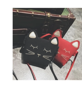 Detail of red and black mini crossbody bags with cat face embroidery on faux leather