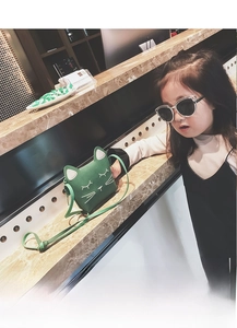 Detail shot of a dark green leather cat-shaped mini crossbody bag with 3D ears and embroidery