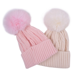 Winter knitted hats for toddlers featuring fluffy pom-poms and classic cable patterns