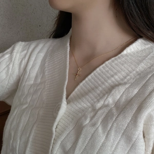 Close-up of a vintage 925 sterling silver cross necklace with red stone on a female model