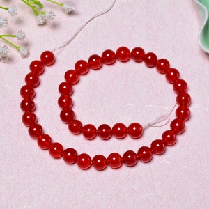 Natural red agate round beads for DIY jewelry making on a soft pink textured background