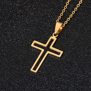 Golden hollow cross necklace pendant on black glitter background with metallic finish