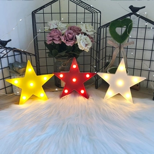 Star-shaped LED night lights in yellow, red, and white on a cozy white plush rug