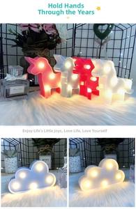 Close-up of unicorn and cloud LED night lights with warm bulbs on a soft plush background