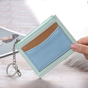 Handheld mint green patchwork wallet with credit card slots and metal keychain