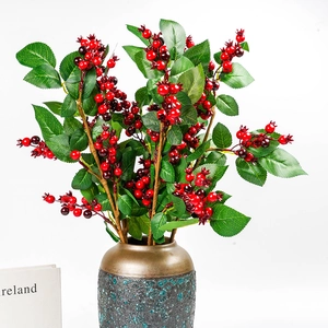 Artificial red berry stems in a vintage ceramic vase for modern home decor and weddings